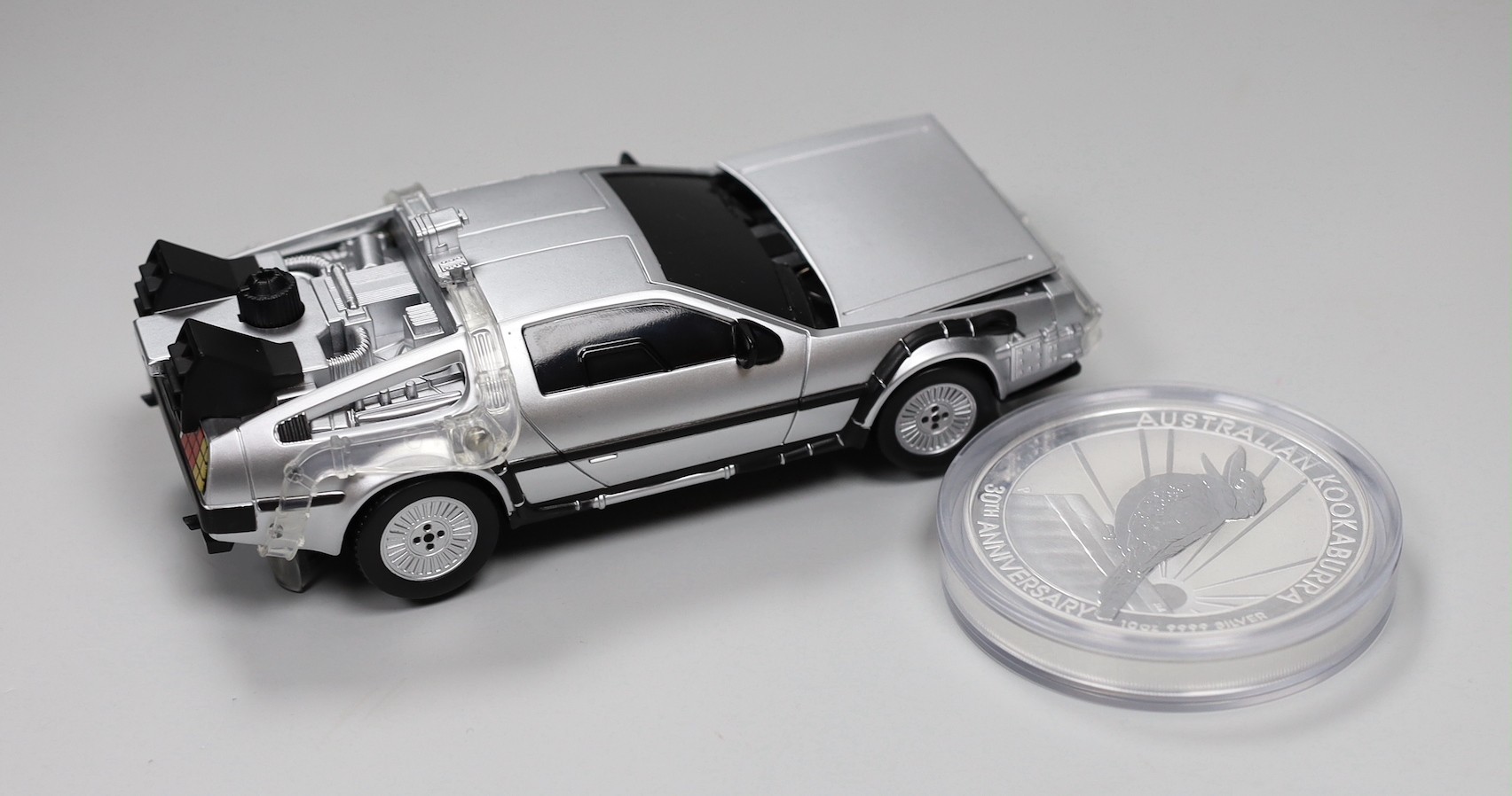 A Back to the Future DeLorean silver coin and model car set and an Australia mint 10oz bullion silver $10